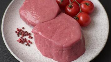 Raw beef eye steak round with salt, spices and herbs prepared for grilling video