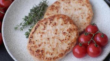 Grilled chicken burger cutlet with salt, spices and herbs on a dark concrete background video