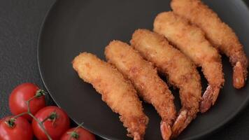 Hot crispy shrimp breaded with salt and spices with white sauce on a dark concrete background video