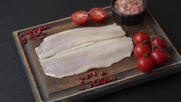 Herring fillet salted and marinated with salt, spices and oil on a dark concrete background video