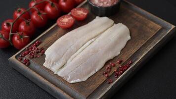 Herring fillet salted and marinated with salt, spices and oil on a dark concrete background video