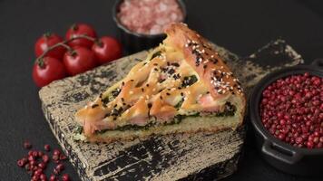 Pieces of quiche with salmon, spinach or broccoli, salt and spices on a dark concrete background video