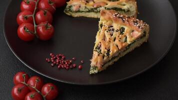 Pieces of quiche with salmon, spinach or broccoli, salt and spices on a dark concrete background video