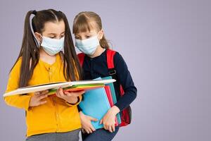 Children wearing face protective mask going back to school during corona virus pandemic. Healthcare and education concept photo