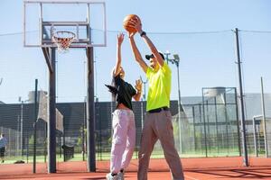 A father and daughter playing basketball in the park photo