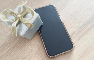 Christmas Day concept. Top view photo of smartphone star ornaments gold background with blank space