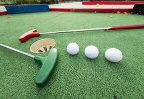 Fun vacation entertainment for summertime. Playing mini golf on green grass outdoors. Setting goals and winning lifestyle concept. Competition at golf course. two crossed sticks. Blank space for copy. photo