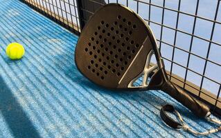 Paddle racket with a ball. Padel court in summer. photo