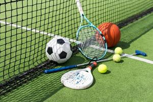 Different sport equipment on green grass, flat lay. Space for text photo