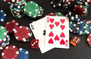 red dice, cards and poker chips, on a black background photo