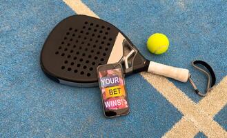 padel tennis and sports betting on a smartphone. Concept of sports bet photo