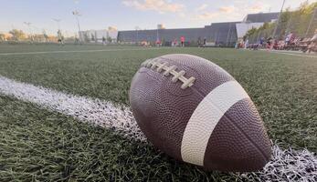 American football resting on a first down line during an American football game. The ball is ready to be snapped to start a new play. Lots of copy space photo