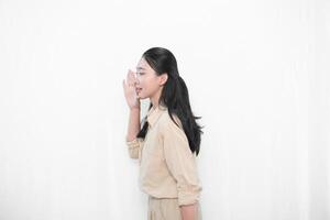 The expression of the Indonesian Asian model woman in white is smiling and making a whispered code or telling photo