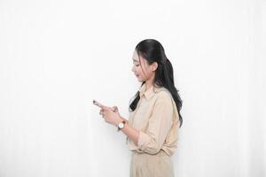 The expression of an Indonesian Asian model woman in white is showing sending a message with a smartphone. photo