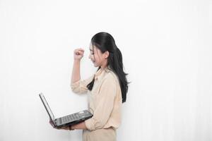 Expression of an Indonesian Asian model woman in white using a laptop photo