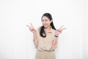 The expression of an Indonesian Asian model woman in white is smiling and making a peace code photo