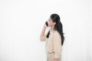 Expression of an Indonesian Asian model woman in white is making a phone call with a smartphone photo