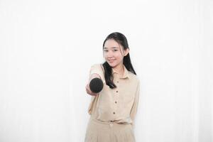 Expression of an Indonesian Asian model woman in white singing using a microphone photo
