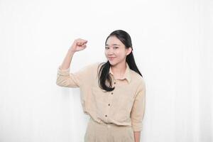 The expression of an Indonesian Asian model woman in white is smiling and making a code of encouragement photo