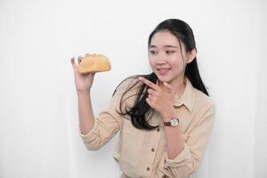 Expression of an Indonesian Asian model woman in white holding bread photo
