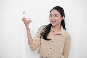 Expression of an Indonesian Asian model woman in white holding water in a bottle photo