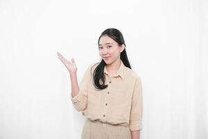 The expression of an Indonesian Asian model woman in white is smiling and raising one hand to the side. photo