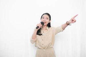Expression of an Indonesian Asian model woman in white singing using a microphone photo