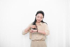 Expression of Indonesian Asian model woman in white dress smiling and looking at watch photo