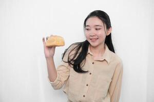 Expression of an Indonesian Asian model woman in white holding bread photo
