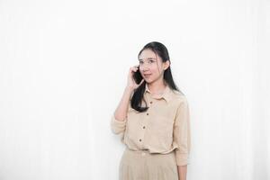 Expression of an Indonesian Asian model woman in white is making a phone call with a smartphone photo