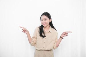 The expression of an Indonesian Asian model woman in white is smiling and making a gesture pointing to the side. photo