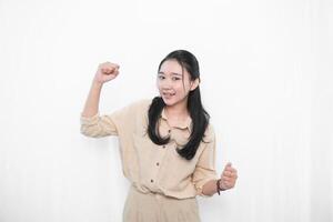 The expression of an Indonesian Asian model woman in a white dress smiling successfully photo