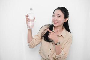 Expression of an Indonesian Asian model woman in white holding water in a bottle photo