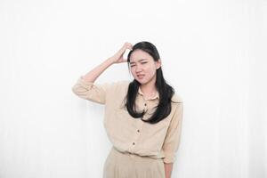 Expression of Indonesian Asian model woman in white dress with headache or confusion photo