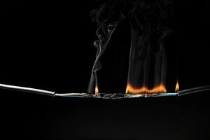 Flames from electric shocks Short-circuited cables cause sparks, explosions, excessive power usage, damaged and non-standard equipment. on a dark black background photo