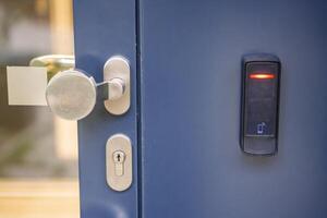 Close up view of door with electric lock with reader of entry system mounted on a house wall. High quality photo