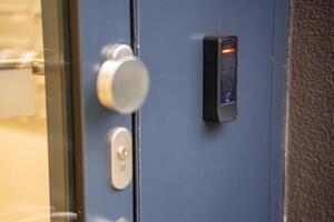 Close up view of door with electric lock with reader of entry system mounted on a house wall. High quality photo