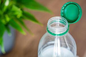 Stationary plastic cap on a PET bottle. The new design means the cap remains attached to the bottle after opening, making the entire package easier to collect and recycle. High quality photo