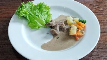 Beef Steak Traditional rujak seasoned with a vegetarian mix of carrot potatoes served on a white plate photo