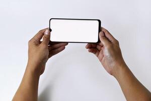 Male hand shows the screen of a mobile smartphone which has a white screen photo