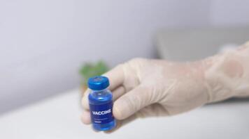 close up of the vaccine being held by the nurse and placed on the table. video