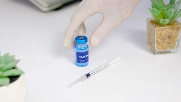 a doctor is placing an injection vaccine on a white table video