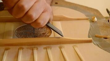 Luthier working with a chisel on a guitar video