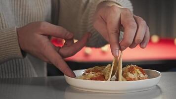 Client in night cafe is trying an unusual taco recipe with seafood and a tortilla. In background see pool table. Close up. video