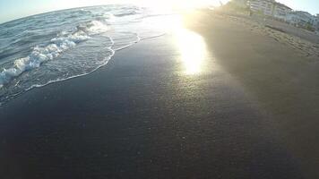 First person view of people running in the beach at sunset in slow video