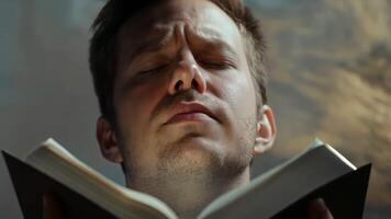 Focused man deeply engrossed in reading a book with concentration and emotion video