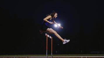 Female Athlete is Running Towards an Obstacle, Hurdling, Jumping Over the Barrier at High Speed while Sprinting in a Race. Cinematic Super Slow Motion video