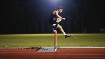 Male Athlete is Running Towards an Obstacle, Hurdling, Jumping Over the Barrier at High Speed while Sprinting in a Race. Cinematic Super Slow Motion video
