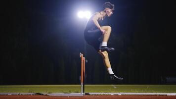 Male Athlete is Running Towards an Obstacle, Hurdling, Jumping Over the Barrier at High Speed while Sprinting in a Race. Cinematic Super Slow Motion video