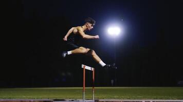 Male Athlete is Running Towards an Obstacle, Hurdling, Jumping Over the Barrier at High Speed while Sprinting in a Race. Cinematic Super Slow Motion video